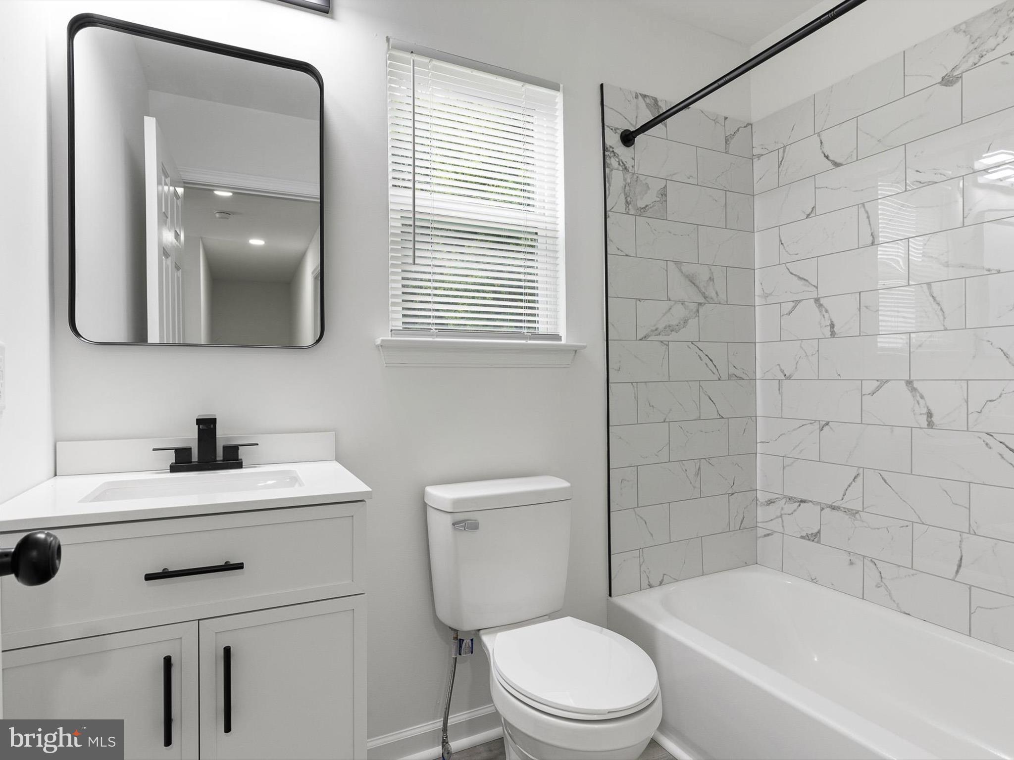 14 3 Rivers Court Newark, DE 19702 - Photo 13 of 21 a bathroom with a toilet a sink a mirror a bathtub and shower