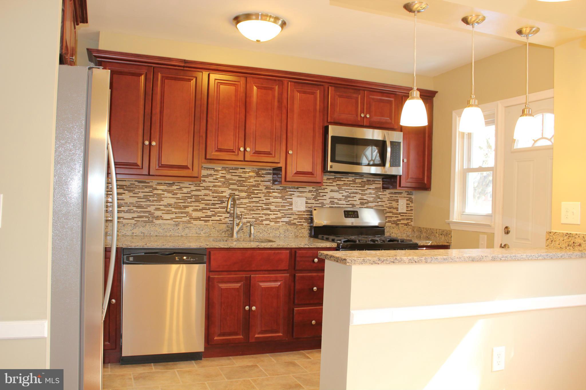 1015 Upnor Road Baltimore, MD 21212 - Photo 6 of 30 a kitchen with granite countertop wooden cabinets and a stainless steel appliances