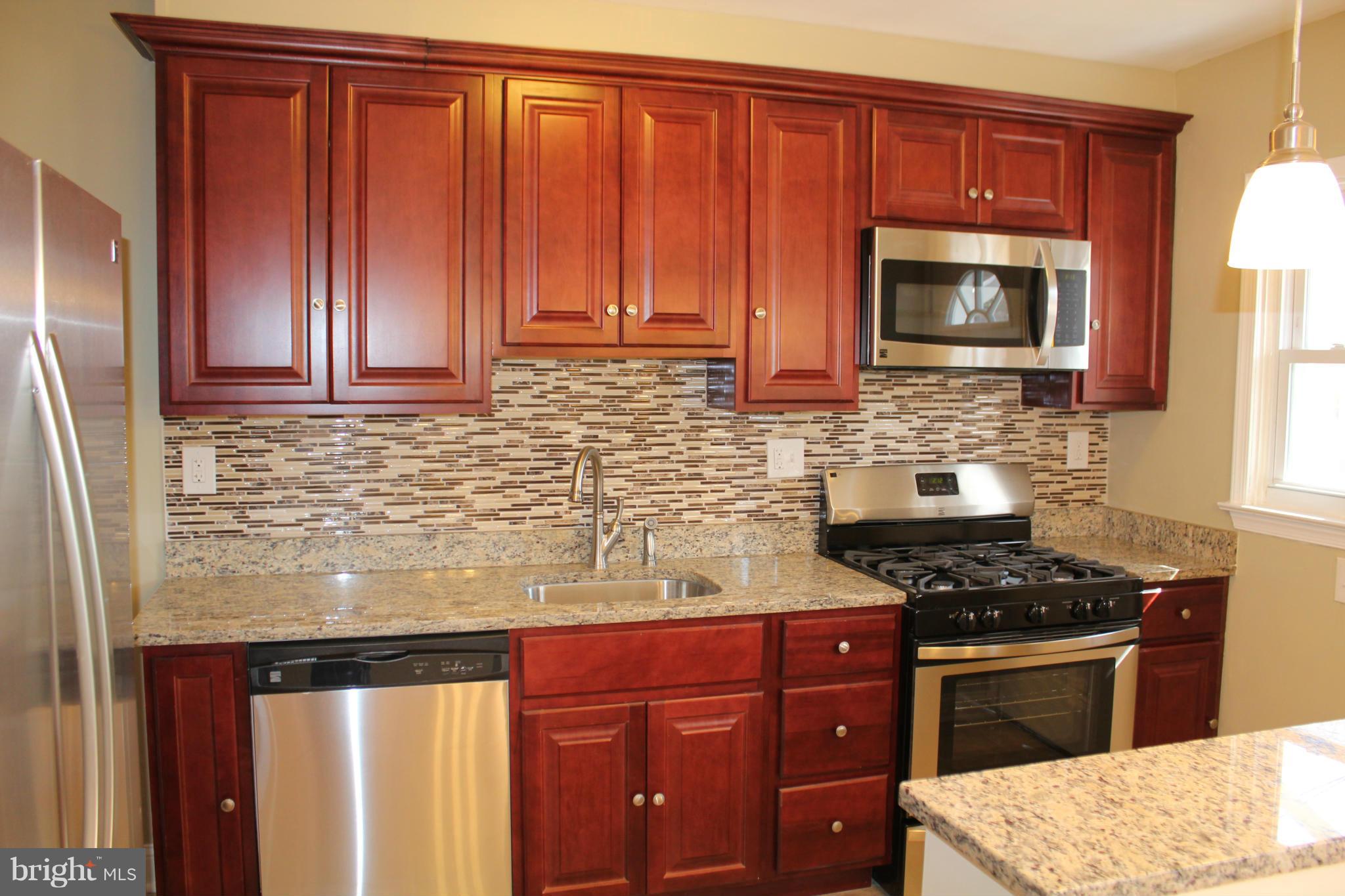 1015 Upnor Road Baltimore, MD 21212 - Photo 8 of 30 a kitchen with stainless steel appliances granite countertop a stove microwave and refrigerator