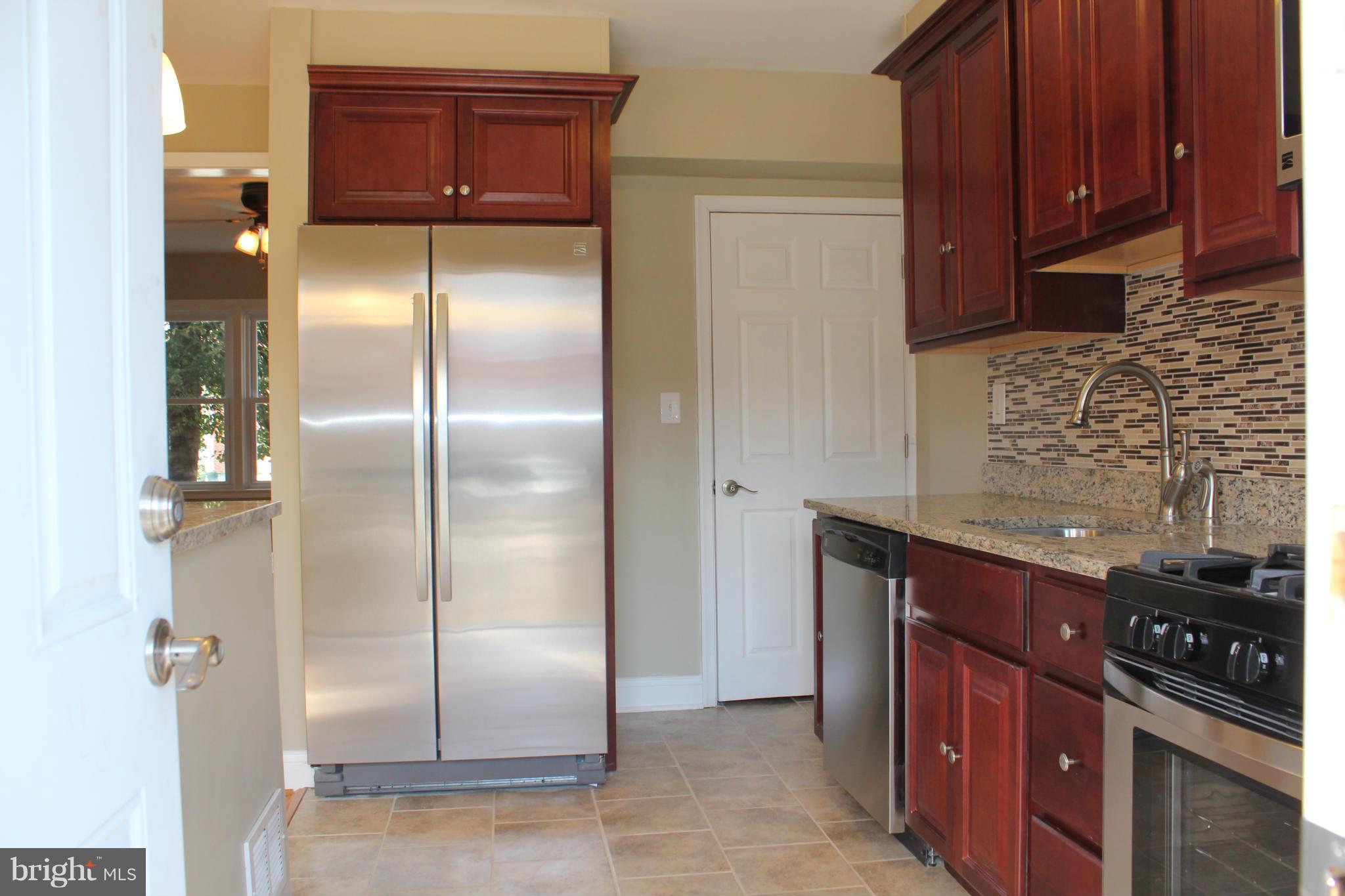 1015 Upnor Road Baltimore, MD 21212 - Photo 10 of 30 a kitchen with stainless steel appliances granite countertop a refrigerator and a stove top oven