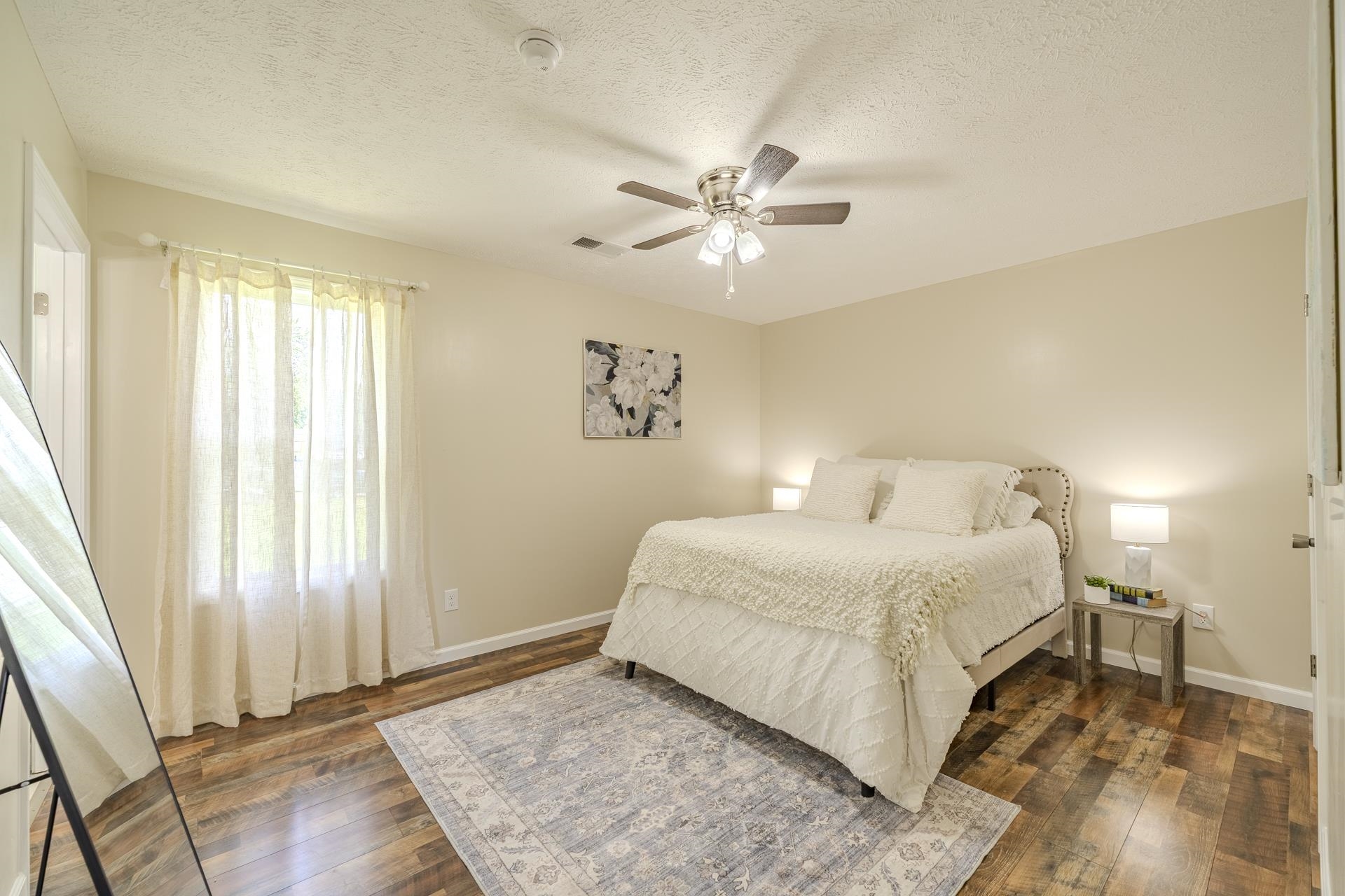 231 Clausel Lane Adamsville, TN 38310 - Photo 11 of 32 a bedroom with a large bed and wooden floor