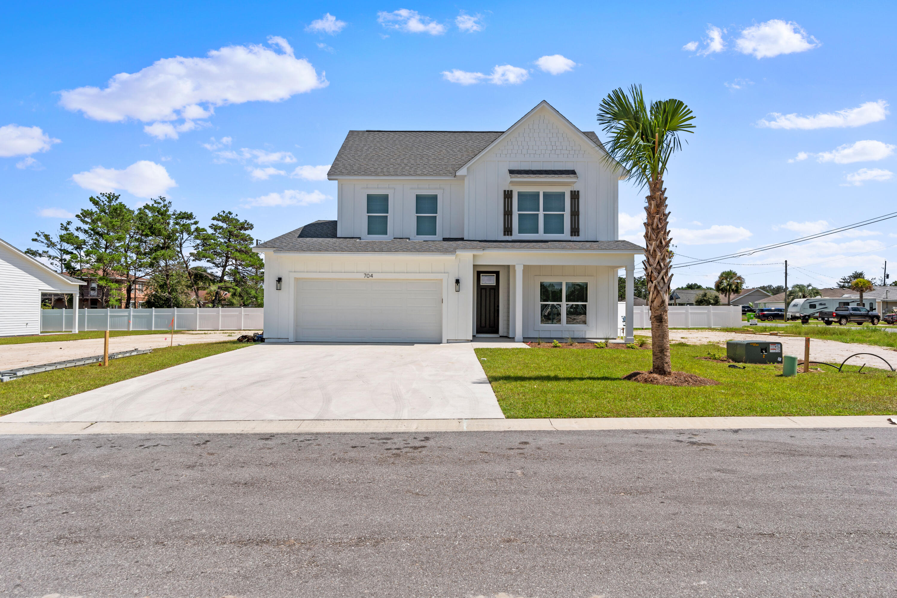 a front view of a house with a yard and trees