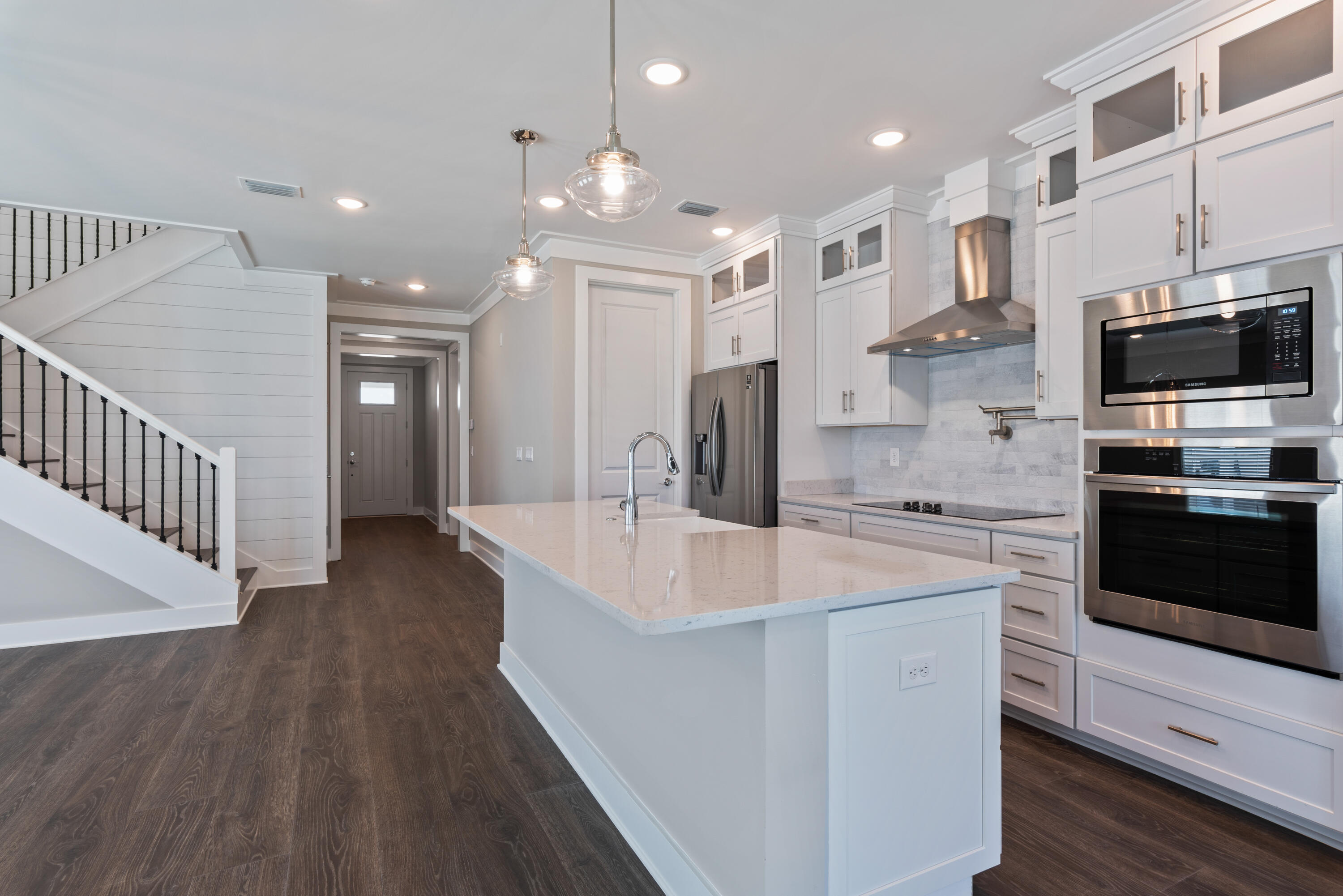 22801 Ann Miller Road Panama City Beach, FL 32413 - Photo 5 of 52 a large kitchen with stainless steel appliances kitchen island granite countertop a large kitchen island a stove a refrigerator a sink and a oven with wooden floor