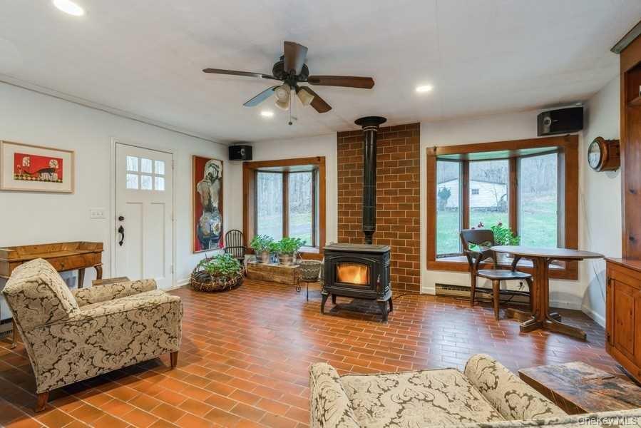 1141 Beekman Road Hopewell Junction, NY 12533 - Photo 10 of 36 a living room with furniture floor to ceiling window and a flat screen tv