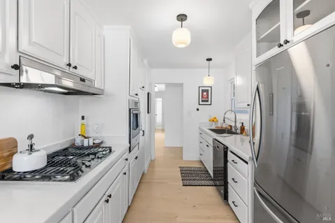 a kitchen with stainless steel appliances a stove a refrigerator and cabinets