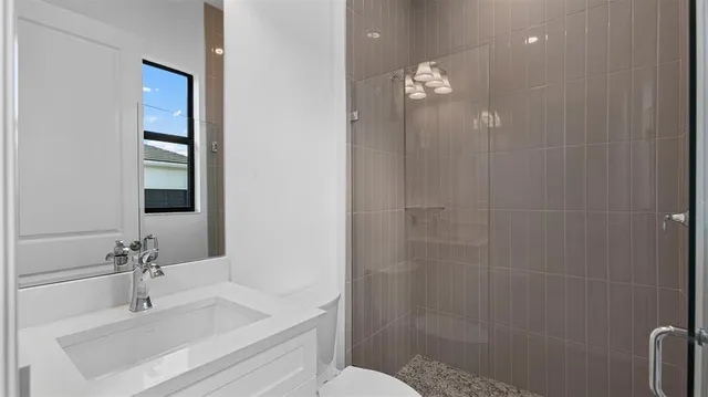 a bathroom with a sink a toilet and shower