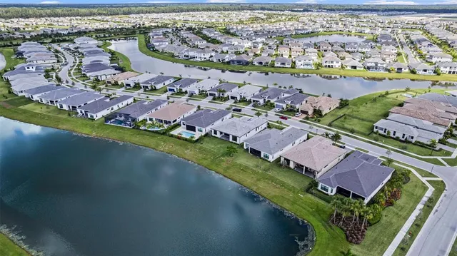 an aerial view of residential houses with outdoor space and river