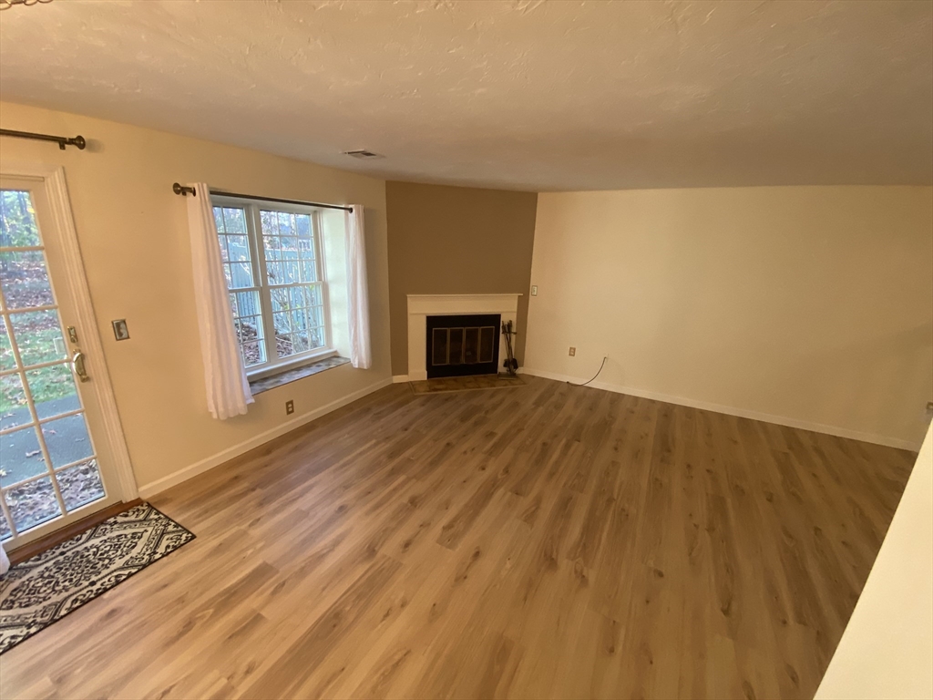501 Ridgefield Circle, Unit B Clinton, MA 01510 - Photo 8 of 17 a view of empty room with wooden floor and fireplace