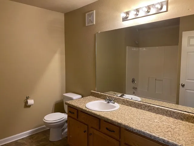 a bathroom with a granite countertop sink and a mirror