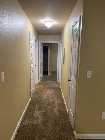 a view of hallway with closet and a window