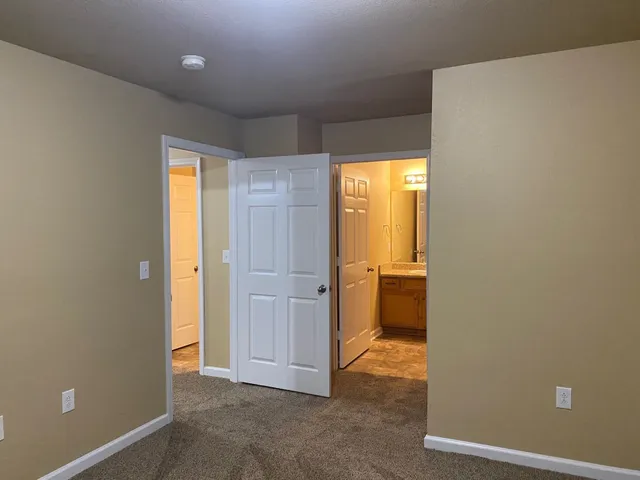 an empty room with a window and a kitchen