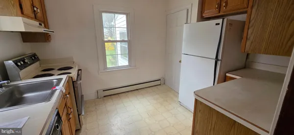 a view of a kitchen with fridge and wooden floor
