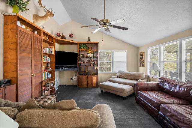 a living room with furniture a flat screen tv and a window