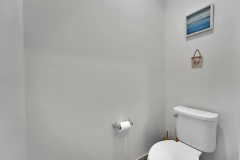 a white toilet sitting next to a white wall