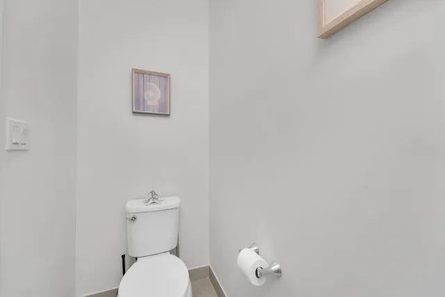a white toilet sitting next to a white walls