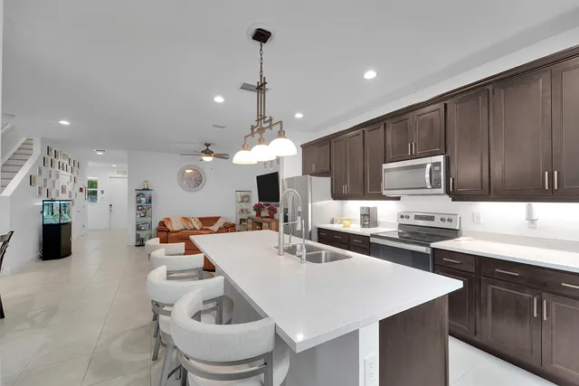a kitchen with granite countertop a sink stove and refrigerator