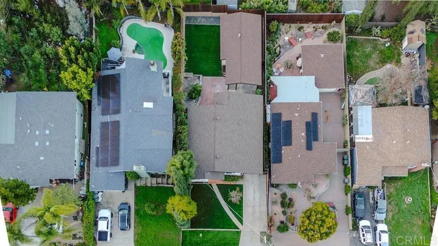 an aerial view of a house with a yard and large trees