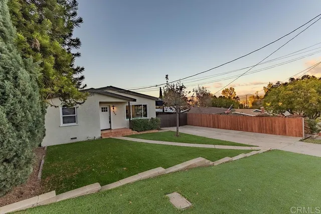 a front view of a house with a yard and trees