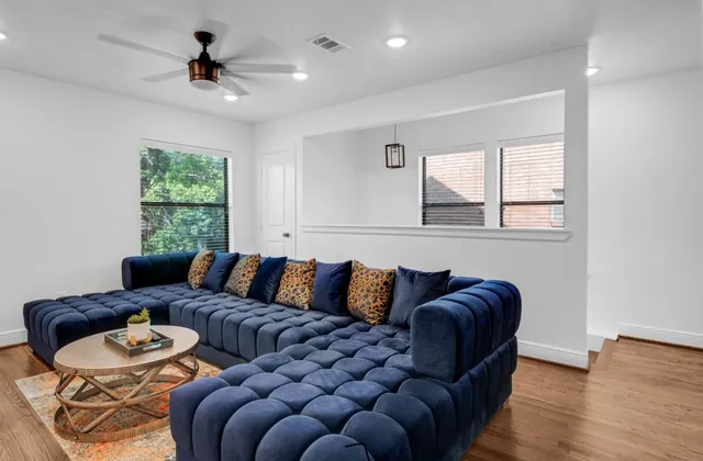 a living room with furniture ceiling fan and a window