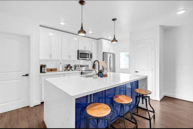 a kitchen with stainless steel appliances a table chairs and a refrigerator