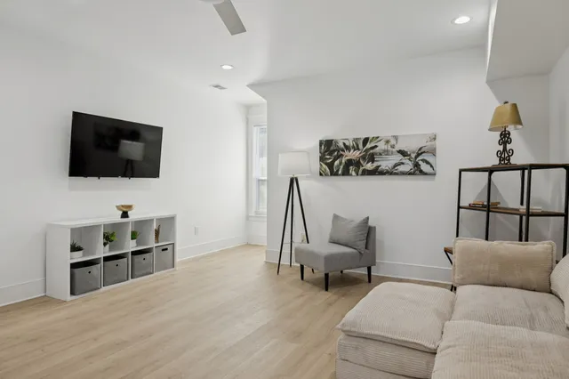 a kitchen with stainless steel appliances kitchen island granite countertop a refrigerator a oven a dining table and chairs with wooden floor