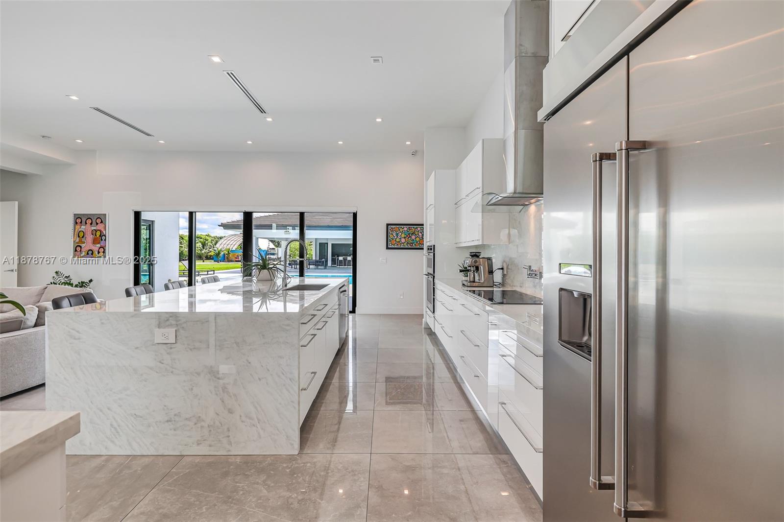 17950 Southwest 192nd Street Miami, FL 33187 - Photo 19 of 53 a large white kitchen with a large window and stainless steel appliances