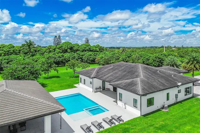 a aerial view of a house with a yard table and chairs