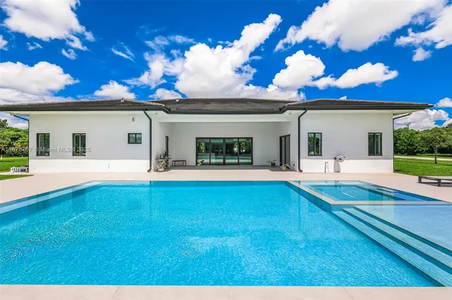 a view of a house with swimming pool and sitting area