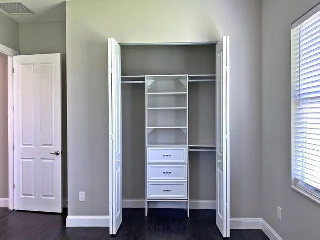 a view of walk in closet with empty racks