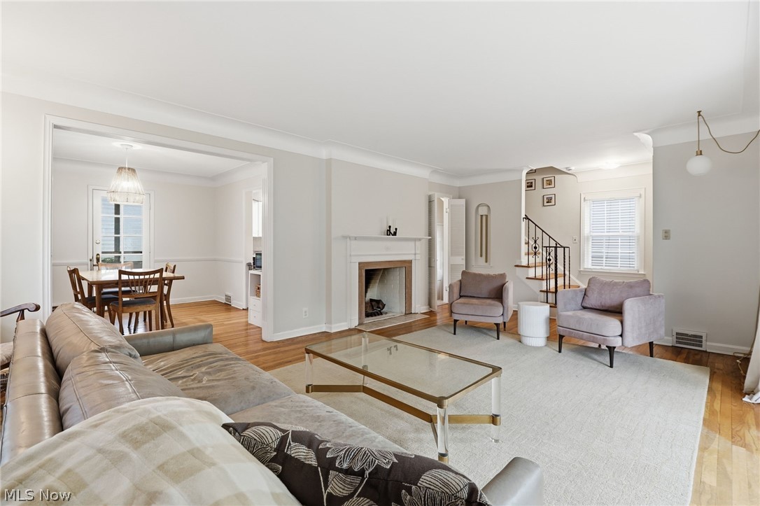 3713 Winchell Road Shaker Heights, OH 44122 - Photo 6 of 38 Spacious living area featuring wood-finish flooring, a decorative fireplace with mantel, and a staircase with a black wrought iron railing