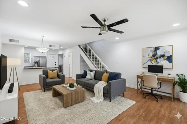 a living room with furniture and a wooden floor