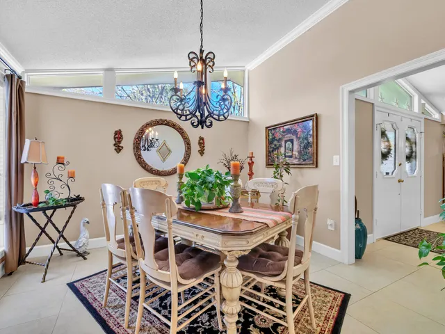 a view of a dining room that has a table and a chandelier