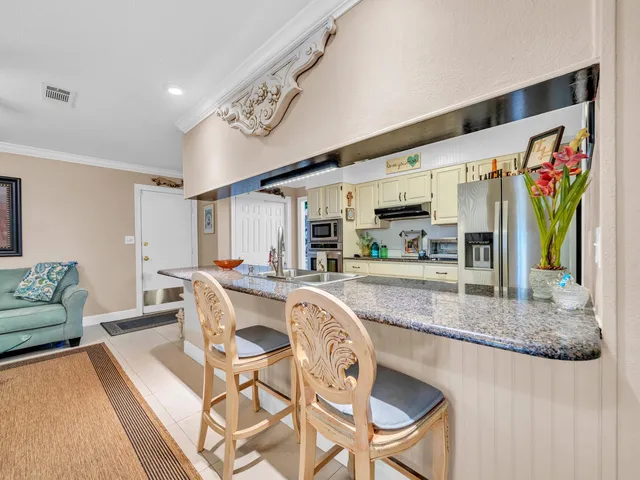 a view of a dining room with furniture a rug and kitchen view