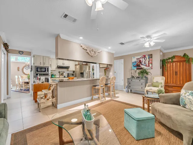 a living room with furniture kitchen view and a chandelier