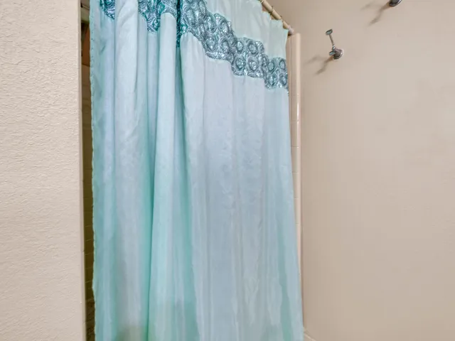 a bathroom with a shower curtain and a curtain