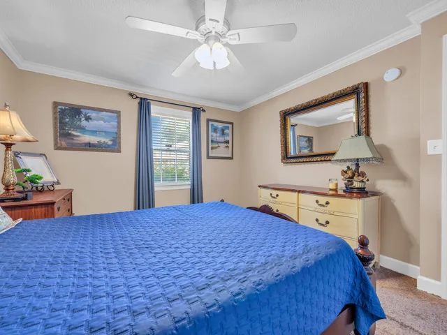 a bedroom with a bed and a dresser next to a window