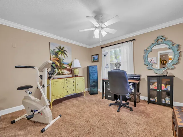 a view of a workspace with furniture and a window