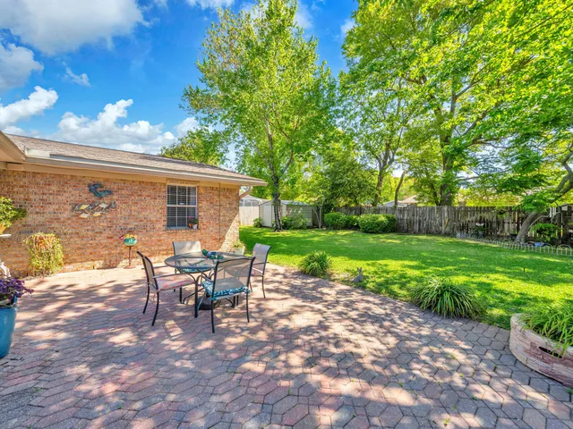 a view of a house with backyard and sitting area