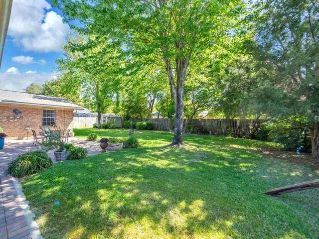a view of a house with backyard and a tree