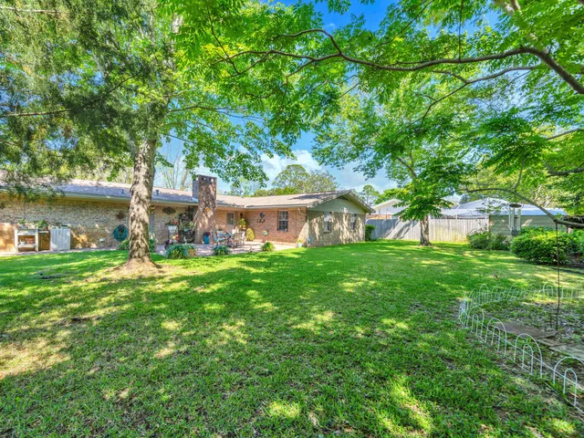 a view of a house with a yard and a tree