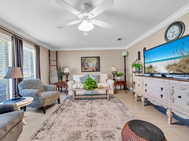 a living room with furniture ceiling fan and a window