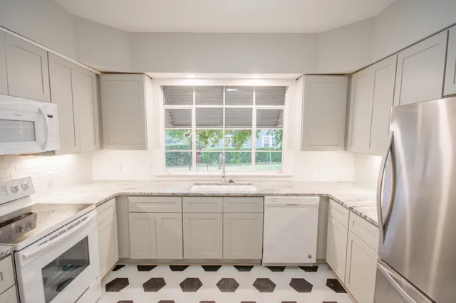 a white kitchen with a sink stove and refrigerator