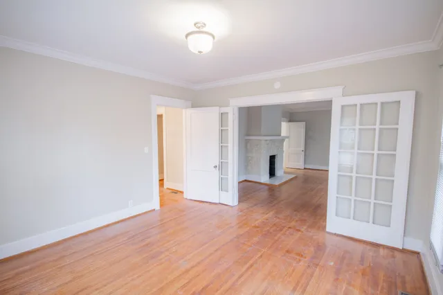 a view of empty room with wooden floor and fireplace