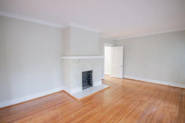 a view of a room with wooden floor and a fireplace