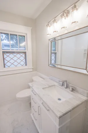 a bathroom with a sink a toilet and a mirror