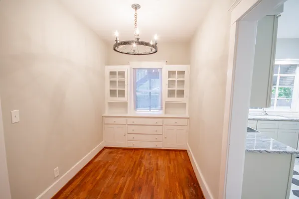 a view of a room with wooden floor and chandelier