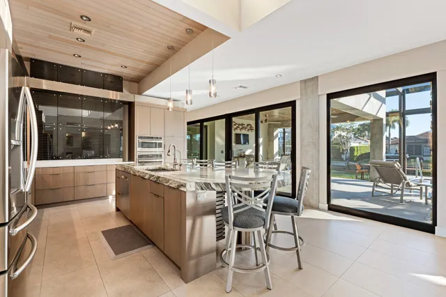 a view of a dining room with furniture large windows and a chandelier