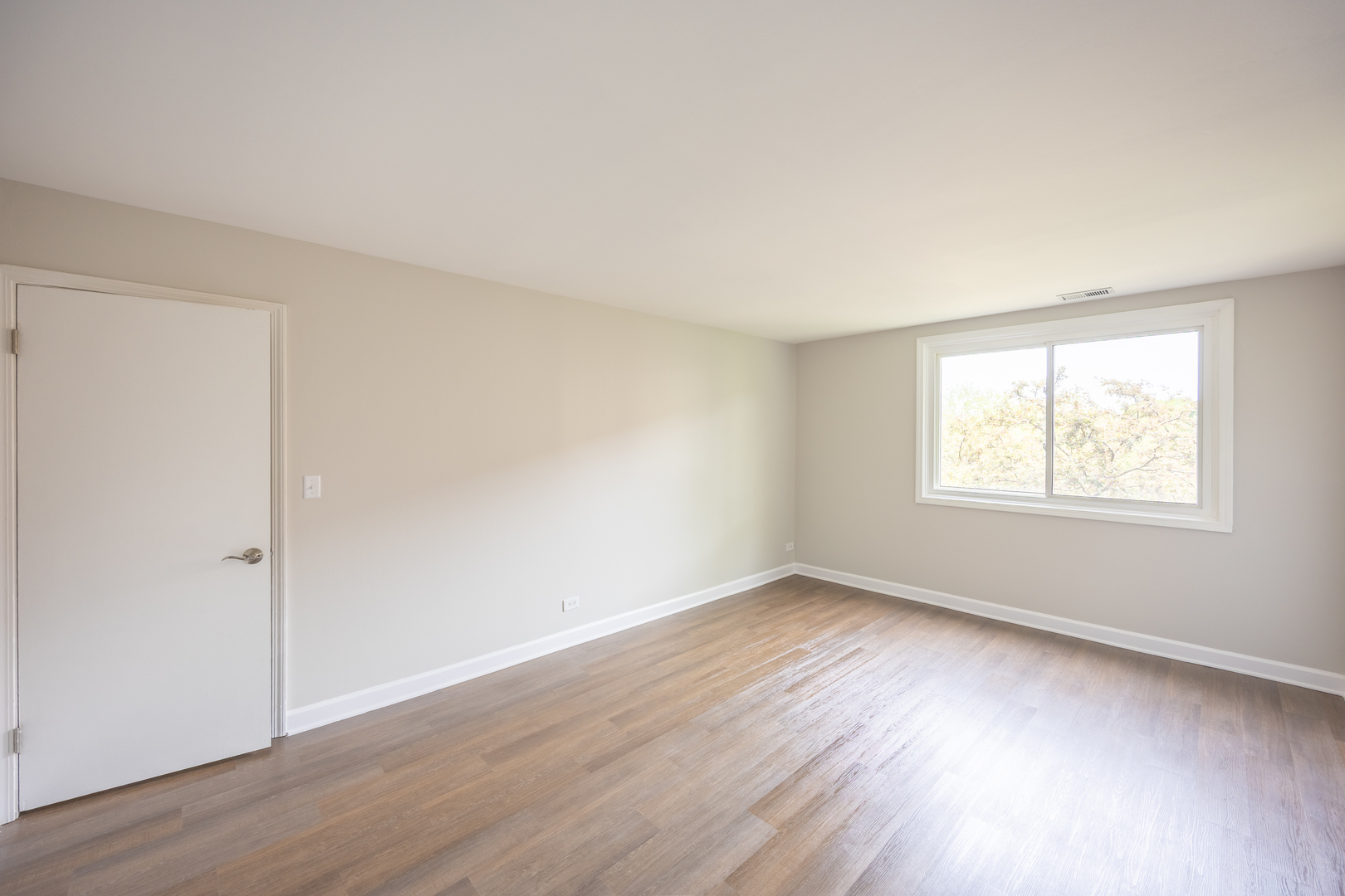 450 Raintree Court, Unit 2B Glen Ellyn, IL 60137 - Photo 15 of 28 an empty room with wooden floor and windows