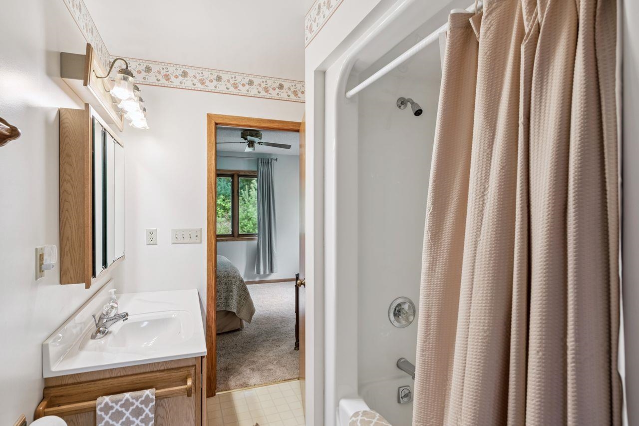 75920 Ondossagon Road Washburn, WI 54891 - Photo 11 of 29 Bathroom with connected bathroom, shower / tub combo with curtain, vanity, and ceiling fan