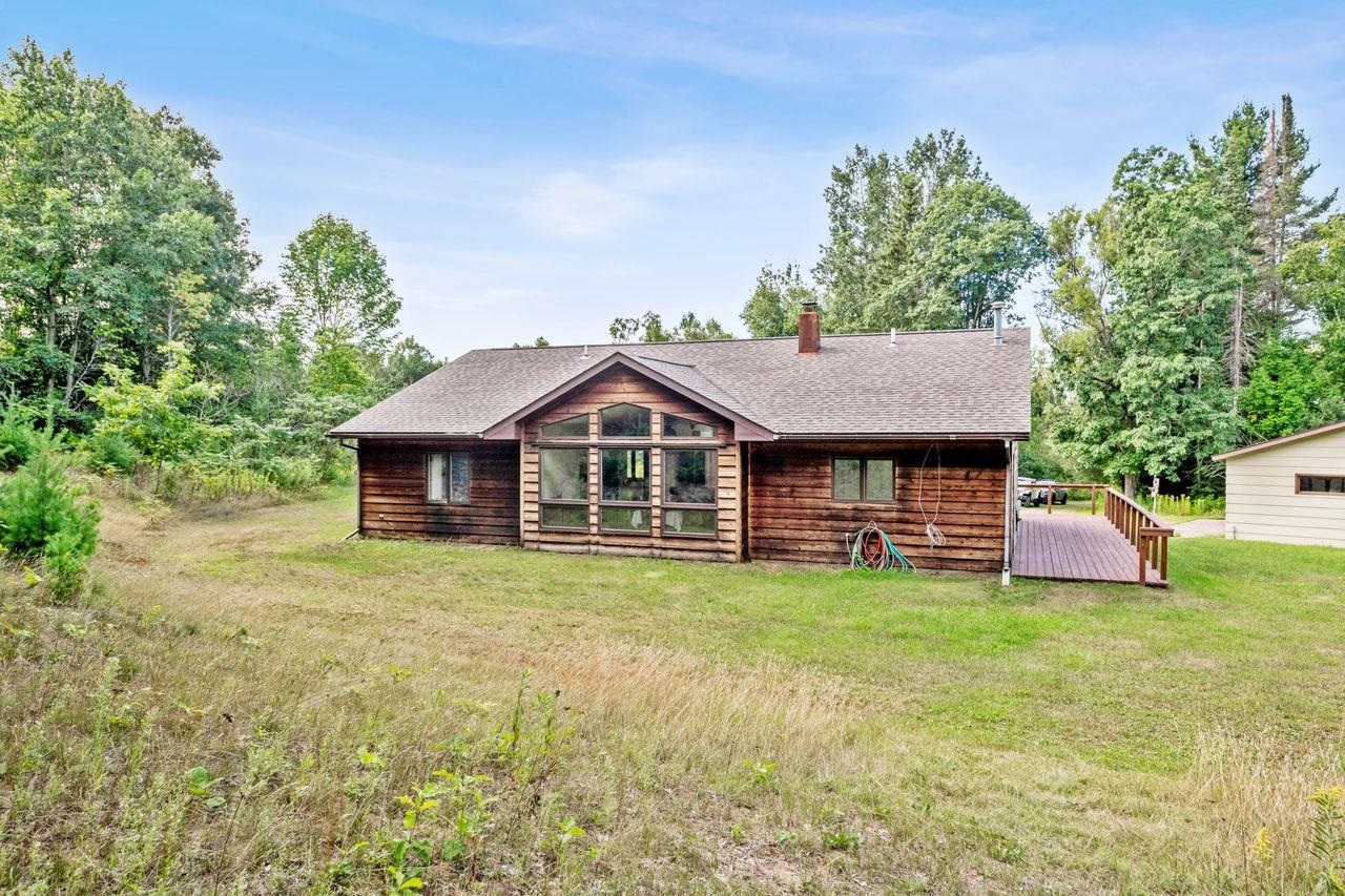 75920 Ondossagon Road Washburn, WI 54891 - Photo 22 of 29 Back of house featuring a shingled roof, a chimney, a yard, and a wooden deck